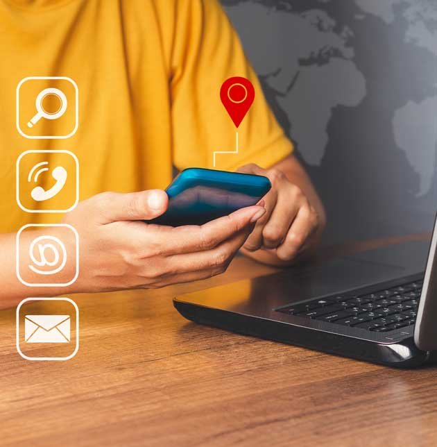 People with smartphone in front of laptop